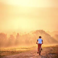 Sticker - young man on bicycle in sunrise light