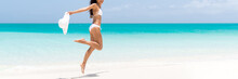 Happy Beach Body Woman Jumping Of Joy With Sun Hat On Caribbean Travel Vacation. Slim Legs Sexy Bikini Girl Sun Tanning Feeling Free. Banner Panorama With Copy Space On Blue Ocean Background