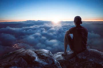 Junger Mann mit weitem Blick über die Wolken