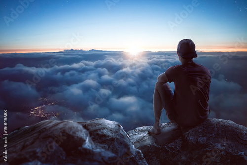 Fotomural Junger Mann mit weitem Blick über die Wolken