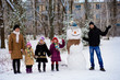 © Svetlana - Big happy family: father, daughters and grandmother sculpt a big real snowman, Happy family have fun in a winter park