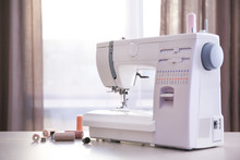 Modern Sewing Machine With Threads On Table
