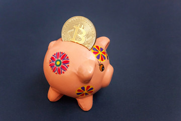 Piggy bank and golden bitcoin coin virtual money on black background. Cryptocurrency and saving concept. Electronic virtual money for web banking and international network payment