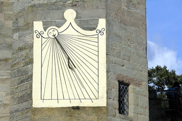 Wall Mural - Old antique sundial attached to a medieval castle wall