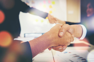 Wall Mural - Business people shaking hands while sitting at the working place, Finish success business good deals meeting