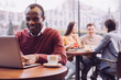 © zinkevych - Digital world. Energetic vigorous young man working on laptop while grinning and sitting at cafe