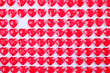 © Evrymmnt - Red pink heart candies laid in a row on white background. Lovers day greeting card gift.