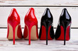 Red and black pump shoes on wooden floor, back view. Classic high heels for sexy rocking look. Women's fashionable footwear.