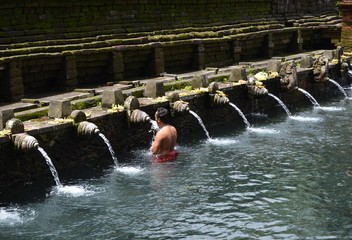 Man drinks holy water at a healing spring