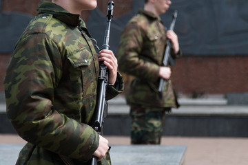 Soldiers with automatic weapons in their hands are on guard of honor