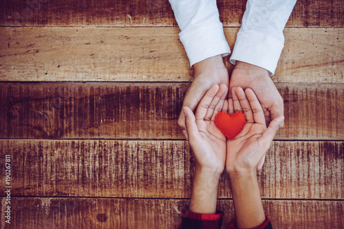 Fotografía hand holding a red heart, valentine's day love, vintage tone