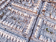 Aerial View Of Snow Covered Traditional Housing Suburbs In England. Snow, Ice And Adverse Weather Conditions Bring Things To A Stand Still In The Housing Estates Of A British Suburb