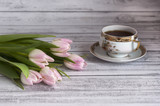 Fototapeta Tulipany - Bukiet różowych tulipanów na drewnianym stole z porcelanową filiżanką herbaty
