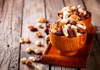 Nuts Mixed in a wooden plate.Assortment, Walnuts,Pecan,Almonds,Hazelnuts,Cashews,Pistachios.Concept of Healthy Eating.Vegetarian.Copy space.selective focus.