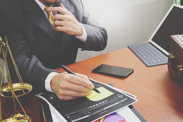 Poster - justice and law concept.Male lawyer in the office with brass scale on wooden table