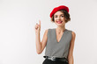 Portrait of a happy woman wearing red beret pointing