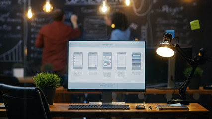 Wall Mural - personal computer with mobile application design showing on the monitor stands on the office desk, i