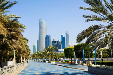Wall Mural - Abu Dhabi Corniche walking area with landmark view of modern bui