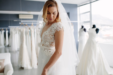 Wall Mural - Beautiful woman trying on bridal gown in boutique