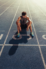 Wall Mural - sprinter relaxing on running track