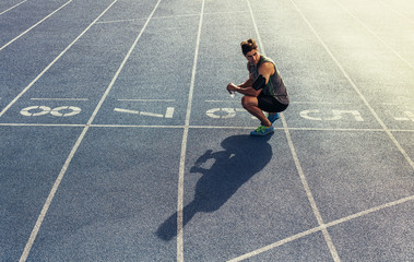 Wall Mural - sprinter sitting on running track