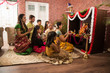 Indian  family performing Ganesh puja or Ganpati Puja in Ganesh Utsav, or holding ganesh idol over white background 
