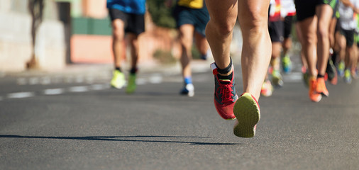 Marathon running in the light of evening,running on city road detail on legs.Copy space