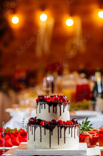 Two Level White Wedding Cake Decorated With Fresh Red Fruits And