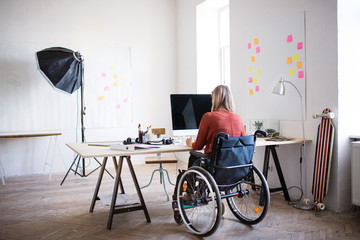 Wall Mural - Businesswoman in wheelchair at the desk in her office.