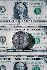 Wall Mural - silver bitcoin coin lying on united states dollars, cryptocurrency concept