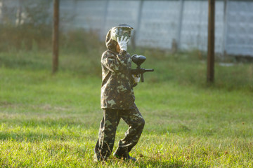 group of kids play paintball at summer field