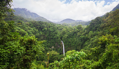 Poster - The La Fortuna Waterfall (Catarata La Fortuna) flows through a very dense jungle and plummets over a large rocky cliff near the town of La Fortuna and near Volcan Arenal, Costa Rica.