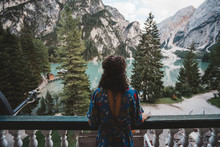 Woman Looking At View While Standing In Balcony Against Mountains And Lake