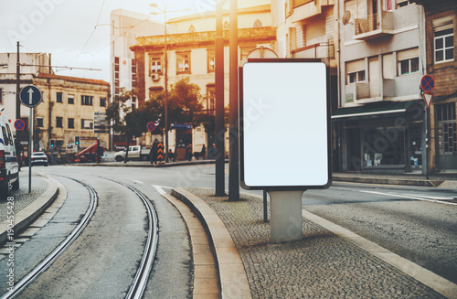 Download Blank White Billboard Placeholder Mockup On City Street Between Road And Tram Line Empty Banner Template In Urban Settings On Pavement Stone Sidewalk With Facades Of Residential Houses Around Stock Photo Adobe