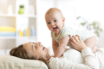 happy mother playing with newborn baby