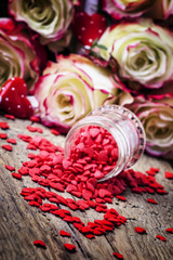 Wall Mural - Red sweet heart, Valentines Day card on background of fresh pink and white roses, selective focus