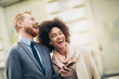 © Mediteraneo - Happy business couple using smart phone outdoors