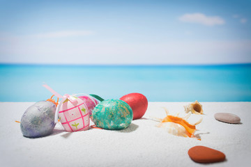 Easter on tropical beach background. Eggs on the white sand. Vacation and travel concept