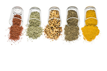 glass jars with various spices on white background with copy space