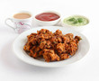 Pakora or pakoda, a traditional and popular Indian vegetarian snack, homemade, with tea and ketchup and coconut chutney as side dishes.