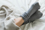 Fototapeta Sypialnia - Feet up in cozy woolly pink socks with cup of tea and candles