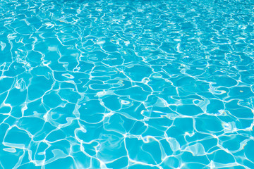 blue and bright water surface and ripple wave with sun reflection in swimming pool