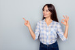 © deagreez - Portrait of attractive, pretty, brunette woman in casual outfit showing ok sign, pointing and looking at copy space