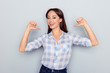 It is me! Portrait of smiling cheerful nice young woman in checkered shirt pointing thumb fingers at her body isolated on grey background, proud of herself, having ego