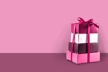 Wall Mural - Gift boxes stacked on a pink background with copy space, concept for Valentine's Day, Mother's Day, Christmas, birthday and anniversary.