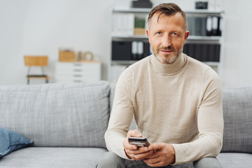 Attractive man relaxing at home on a couch
