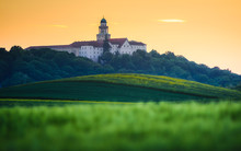 Pannonhalma Archabbey With Wheat Field On Sunset Time