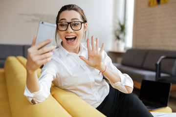 Sticker - Young cheerful emotional business lady talking by mobile phone.