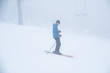 Skier silhouette in white ski resort. Fog in background