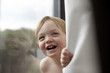 © Gregory Miller - Portrait of smiling toddler boy by window